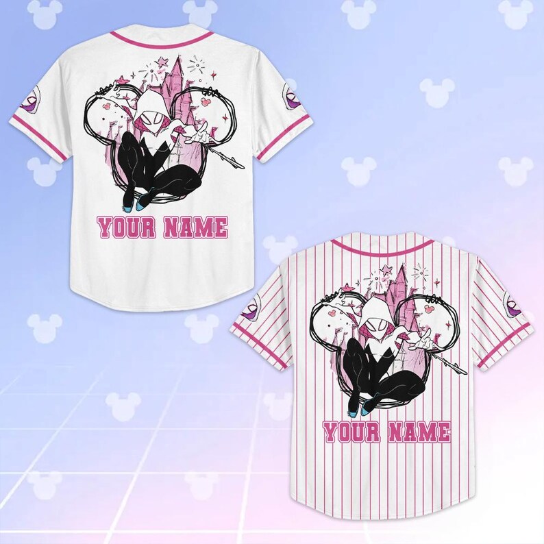 May include: White baseball jersey with pink accents and a cartoon graphic of a superhero. The jersey features the text "YOUR NAME" in pink. The jersey has short sleeves and a button-up front.