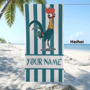May include: A rectangular beach towel featuring a vertical teal and white striped pattern. The center displays a cartoon rooster with a red comb and yellow neck feathers. Below the rooster, a white horizontal band contains the text YOUR NAME.