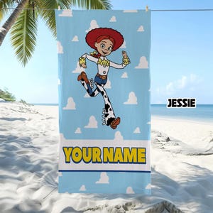 Puede incluir: Una toalla de playa azul claro con un patr&oacute;n repetido de nubes blancas y un gr&aacute;fico central del personaje Jessie de Toy Story. La toalla incluye el texto JESSIE y una banda amarilla con el texto de marcador de posici&oacute;n YOUR NAME.
