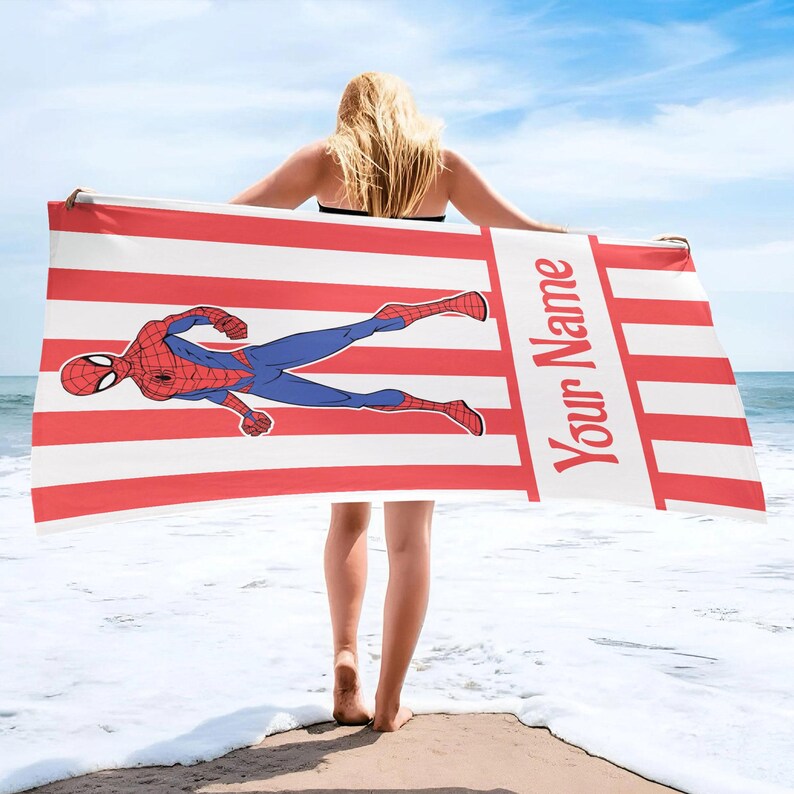 May include: A rectangular beach towel featuring a red and white vertical striped pattern. The towel displays a graphic of a red and blue superhero in a dynamic pose and includes the text Your Name printed vertically in red on the right side.