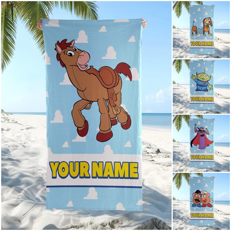Op de afbeelding: Een rechthoekige strandhanddoek met een lichtblauwe achtergrond en witte wolkenpatronen. De handdoek toont een bruin stripfiguurpaard met een zadel en de tekst YOUR NAME in grote gele letters aan de onderkant van het ontwerp.