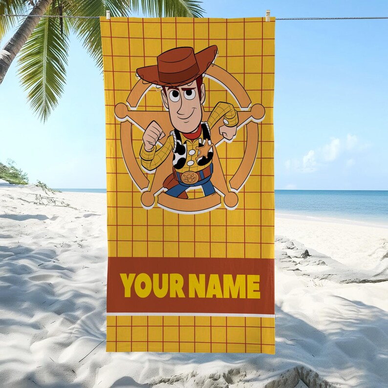 May include: A rectangular beach towel featuring a yellow grid pattern background. In the center, a cartoon cowboy character wearing a brown hat, yellow shirt, and cow-print vest stands inside a large tan sheriff star. The text YOUR NAME is printed below.