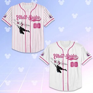 May include: Two baseball jerseys, one striped and one solid white, featuring the Ghost-Spider character. Both jerseys have pink accents, the character's name, and the number "00". The jerseys have short sleeves and a button-up front.