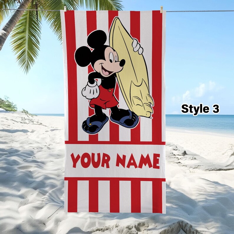 May include: A rectangular beach towel featuring vertical red and white stripes, a graphic of Mickey Mouse holding a yellow surfboard, and the text YOUR NAME in red letters. The towel is displayed hanging on a line with the text Style 3 visible.