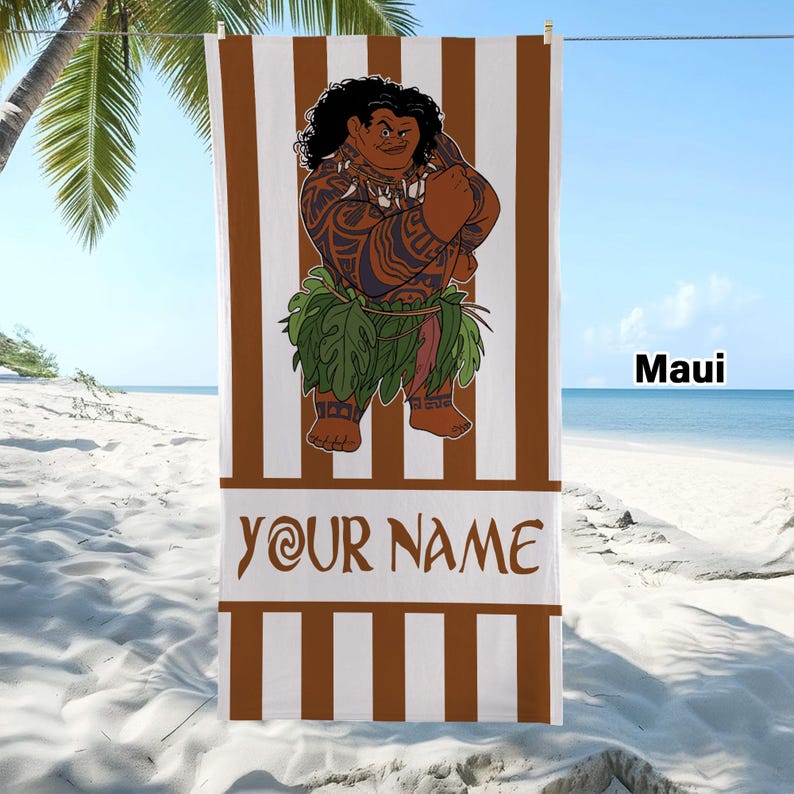 May include: A rectangular beach towel featuring vertical brown and white stripes. The center displays a cartoon character with dark curly hair, tribal tattoos, and a green leaf skirt. Below the character, the text reads YOUR NAME in brown letters.