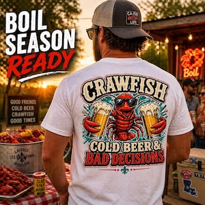 Puede incluir: Camiseta blanca con un gráfico de un cangrejo rojo con gafas de sol, sosteniendo dos jarras de cerveza. El texto de la camiseta dice "CRAWFISH, COLD BEER & BAD DECISIONS". Las palabras "BOIL SEASON READY" están encima de la camiseta. Se lleva una gorra "Cajun Life".