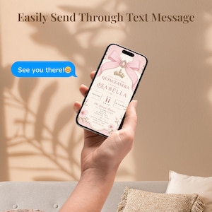 K&ouml;nnte beinhalten: Ein Smartphone zeigt eine Quincea&ntilde;era-Einladung mit einem rosa Schleifen- und Kronen-Design. Der Text auf dem Telefon lautet "Einfach per SMS senden" und "Wir sehen uns dort!". Die Einladung enth&auml;lt den Namen "Isabella" und das Datum 11. Mai.