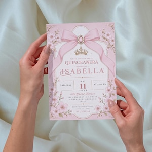 K&ouml;nnte beinhalten: Eine rosa Quincea&ntilde;era-Einladung mit floralen und Schleifen-Akzenten. Die Einladung zeigt den Namen "Isabella" und Veranstaltungsdetails, einschlie&szlig;lich Datum, Uhrzeit und Ort. Das Design umfasst eine Krone und dekorative Verzierungen.