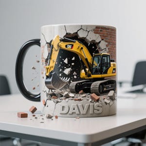 Peut inclure: Mug en c&eacute;ramique blanche avec une anse noire. Il pr&eacute;sente un design d'une excavatrice CAT jaune per&ccedil;ant un mur de briques. Le mot "DAVIS" est imprim&eacute; sur la base. L'excavatrice a des chenilles noires et un godet noir.