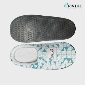 May include: A pair of slippers featuring a white and teal geometric triangle pattern on the top with the text RINTUZ PRINT YOUR ART. The black rubber sole has a textured triangular grip pattern and displays the size 265 12.5 and 40-41.