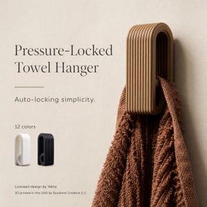 May include: A tan, ribbed, U-shaped pressure-locked towel hanger mounted on a wall, holding a brown textured towel. The text reads Pressure-Locked Towel Hanger, Auto-locking simplicity, 12 colors, Licensed design by Yekta, 3D printed in the USA.