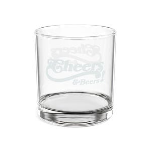 Puede incluir: Un vaso transparente y cilíndrico con una base gruesa. El vaso presenta las palabras "Cheers & Beers!" en una fuente estilizada de color claro. El vaso está diseñado para bebidas.