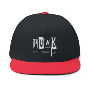 May include: Black flat-brimmed cap with a red brim and a red button on top. The word "PUNK" is printed in white block letters on the front, with the words "RAW & REBELLIOUS" below.