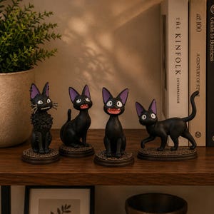 May include: Four black cat figurines with large pointed ears and purple inner ears, each on a circular base. One cat has textured fur, while the others are smooth. They display various expressions with open mouths, wide eyes, and long whiskers.