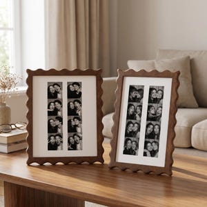Puede incluir: Dos marcos de fotos rectangulares de madera con un diseño de borde ondulado y festoneado. Cada marco cuenta con un paspartú blanco que contiene dos tiras verticales de fotos en blanco y negro estilo fotomatón con dos personas haciendo gestos.