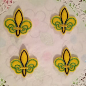 May include: Four yellow felt fleur-de-lis with green and black embroidery.