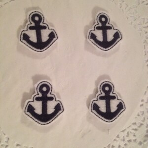 May include: Four navy blue anchor iron-on patches on a white background. The anchors are outlined in white.