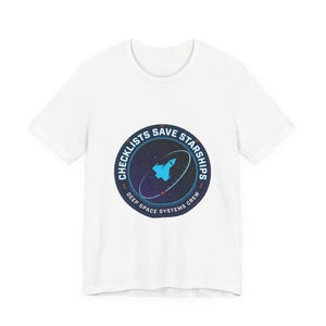 May include: White t-shirt with a circular graphic featuring a spaceship and the text "CHECKLISTS SAVE STARSHIPS" in a navy blue ring. The graphic also includes the text "DEEP SPACE SYSTEMS CREW".