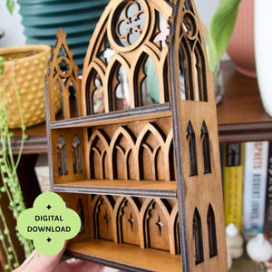 Op de afbeelding: Een houten boekenplank met een gotisch kathedraalontwerp. De plank heeft twee planken en is gemaakt van lichtbruin hout. Het ontwerp omvat gewelfde ramen en decoratieve uitsparingen. De tekst "DIGITALE DOWNLOAD" is zichtbaar.