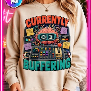 May include: Beige sweatshirt with a colorful graphic design. The design features a brain with goggles, wires, and the words "CURRENTLY BUFFERING." Additional text includes "THOUGHT DOWNLOAD IN PROGRESS," "SQUIRREL ALERT," and "DID I LOCK THE DOOR? ...MAYBE."