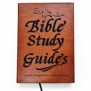 May include: A brown leather-textured book with the black embossed text "Bible Study Guide's" and a small cross symbol at the top. Below the title, the text reads "~3 Guide to Deepen Your Faith and Knowledge~" in a smaller black font.