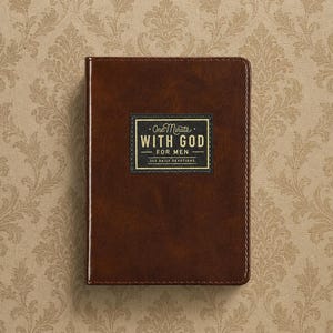 May include: A dark brown, rectangular devotional book with a smooth, leather-like cover. Centered on the front is a black rectangular label with gold text that reads: One Minute WITH GOD FOR MEN 365 DAILY DEVOTIONS, framed by a thin gold border.