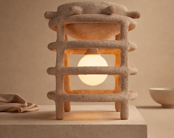 Handgemaakte sculpturale keramische bijzettafel onder verlichte steengoed vloerlamp rustige luxe Japandi wabi sabi gekooide omgevingslichtarmatuur