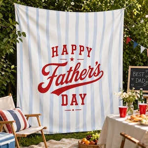 May include: A white and light blue striped banner with the words "HAPPY Father's DAY" in red script. The banner is hanging outdoors, with a picnic setup in the foreground, including a table, chairs, and food.