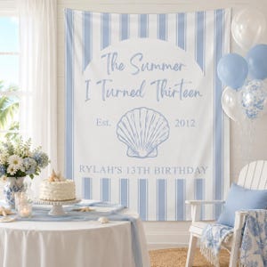 Könnte beinhalten: Ein blau-weiß gestreifter Hintergrund mit dem Text "The Summer I Turned Thirteen" und einer Muschel-Grafik. Ein Tisch ist mit Kuchen, Blumen und Dekorationen gedeckt. Ballons und ein Stuhl sind ebenfalls vorhanden.