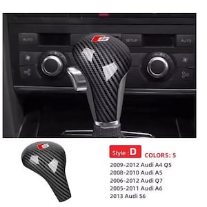 Puede incluir: Pomo de palanca de cambios estilo D de fibra de carbono con el logotipo Audi S en rojo. El pomo se muestra instalado en la consola de un coche. La imagen también muestra una versión más pequeña del pomo y una lista de modelos Audi compatibles.