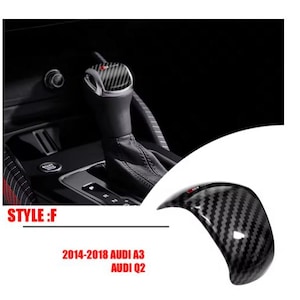 Può includere: Copertura del cambio in fibra di carbonio per i modelli Audi A3 e Q2. La copertura presenta un motivo intrecciato nero e grigio e un accento rosso. L'immagine mostra anche il cambio e l'interno di un'auto. Il testo sull'immagine recita "STYLE: F" e "2014-2018 AUDI A3 AUDI Q2".