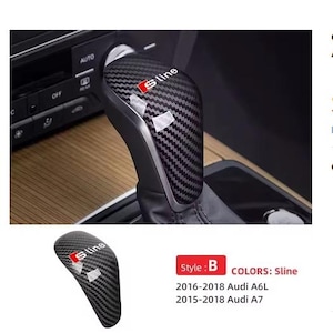 Op de afbeelding: Schakelknop van koolstofvezel met het "Sline" logo in rood en wit. De knop is geïnstalleerd in het interieur van een auto, met een tweede afbeelding van de knop. Compatibel met de modellen Audi A6L 2016-2018 en Audi A7 2015-2018.