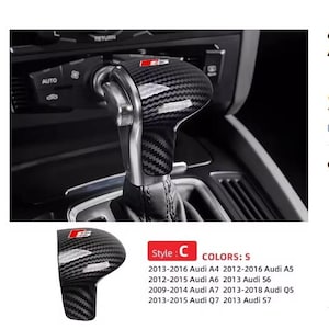 May include: Carbon fibre style gear shift knob with a red and silver logo. The image shows the gear shift knob installed in a car. The text in the image lists compatible Audi models.