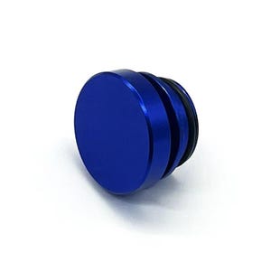 May include: A vibrant blue, cylindrical object with a flat top and a grooved side. The object has a metallic sheen and appears to be made of metal. The object is likely a plug or stopper.