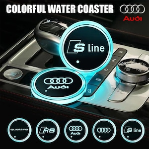 Puede incluir: Posavasos iluminados para coche con el logotipo de Audi y el texto "S line". Los posavasos tienen un borde azul brillante y se muestran en el interior de un coche. Se muestran diseños adicionales con "quattro" y "RS".