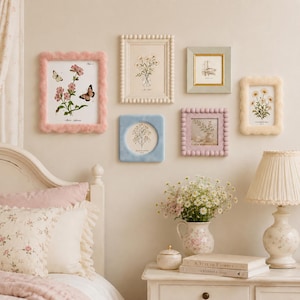 May include: A gallery wall arrangement featuring six rectangular and square picture frames in various pastel colours including pink, cream, light blue, and lavender, surrounding botanical prints of flowers and butterflies on a beige wall.