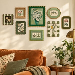 Könnte beinhalten: Eine Galerie-Wand mit acht gerahmten botanischen und Vogel-Drucken in verschiedenen grünen, weißen und goldenen Rahmen. Die Rahmen haben gewellte, perlenartige und rechteckige Kanten und zeigen Illustrationen von Blumen, Vögeln und Pflanzen.
