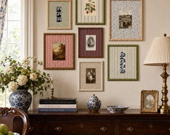 May include: A gallery wall featuring six rectangular picture frames with patterned mats, surrounding a central arrangement of vintage-style photographs and botanical prints, displayed above a dark wooden sideboard with blue and white ceramics.