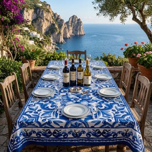Puede incluir: Una mesa de comedor rectangular preparada para seis con un mantel de estampado floral blanco y azul, cuatro botellas de vino, seis platos de cerámica blanca, cristalería transparente y cubiertos de plata en una terraza de piedra.