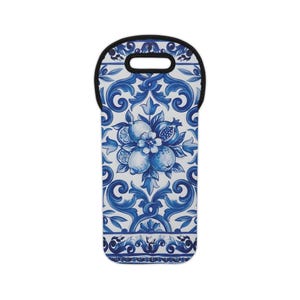 May include: A blue and white wine bottle tote bag with a decorative floral and fruit design. The design features lemons, pomegranates, and flowers in a classic blue and white color scheme. The tote has a black handle at the top.