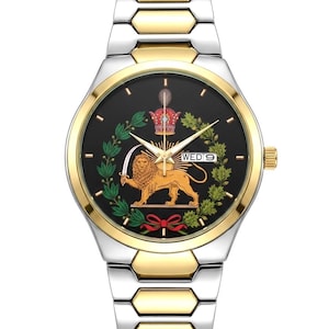 Könnte beinhalten: Zwei-farbige Armbanduhr mit silbernem und goldenem Armband. Das schwarze Zifferblatt zeigt einen goldenen Löwen mit Schwert, Krone und dem Text "WED 9". Die Uhr hat goldene Akzente.