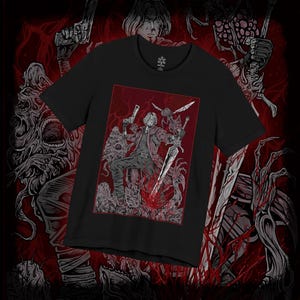 May include: Black crew neck t-shirt with a red and grey graphic of a character with a sword and guns, surrounded by monsters. The design is framed in a red border, set against a dark red background.