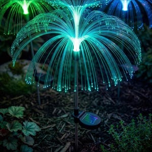 Puede incluir: Luces de jardín con energía solar con un diseño de fibra óptica. Las luces tienen una combinación de colores verde y azul, que se asemeja a una medusa o una flor. Cada luz está montada en una estaca de metal con un panel solar.