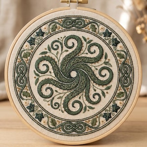 Op de afbeelding: Een ronde borduurring met een gebroken witte stof met een centraal donkergroen ontwerp van kronkelende tentakels. Het patroon is omgeven door een cirkelvormige rand van groene klimopbladeren, kleine witte bloemetjes en ingewikkeld vlechtwerk.