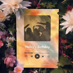 Op de afbeelding: Een kaart met de tekst "Hailey's Birthday" en een silhouetafbeelding van mensen. De kaart heeft een muziekspelerinterface met afspeel-, overslaan- en toevoegknoppen. De achtergrond is een mix van oranje, geel en wit, omringd door bloemen.