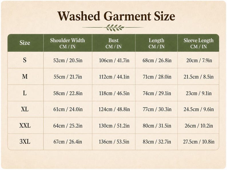 May include: A Washed Garment Size chart with a cream background and dark green headers. The table lists sizes S through 3XL with corresponding measurements for shoulder width, bust, length, and sleeve length in both centimeters and inches.