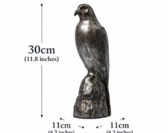 May include: A metallic silver-toned falcon statue perched on a textured rock base. The sculpture features the text DIMENSIONS, 30cm (11.8 inches) in height, 11cm (4.3 inches) in width, and WEIGHT: APPROX 1.4KG printed around the object.