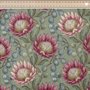 May include: A fabric with a repeating floral pattern. The design features large, pink protea flowers with yellow centers, surrounded by green leaves and blue-green berries, set against a muted green background. The fabric has a textured appearance.