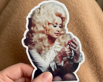 May include: A die-cut sticker featuring a portrait of a person with voluminous blonde hair, wearing a white long-sleeved blouse with ruffled cuffs. The person is looking down at a small, dark pink flower held in their hands, with visible rings.