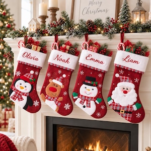 Puede incluir: Cuatro calcetines navideños rojos con puños blancos, personalizados con los nombres Olivia, Noah, Emma y Liam. Los calcetines presentan personajes aplicados que incluyen un pingüino, un reno, un muñeco de nieve y Santa Claus, todos con gorros de cuadros.
